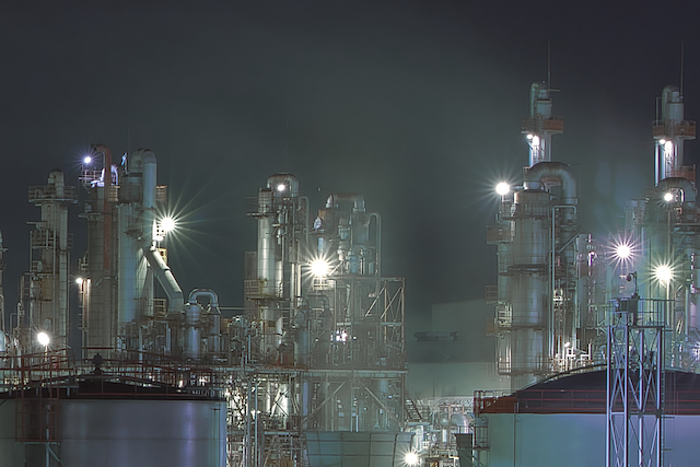 一部の工場夜景の切り取り写真。タンクや煙突、煙突から出ている煙の様子。