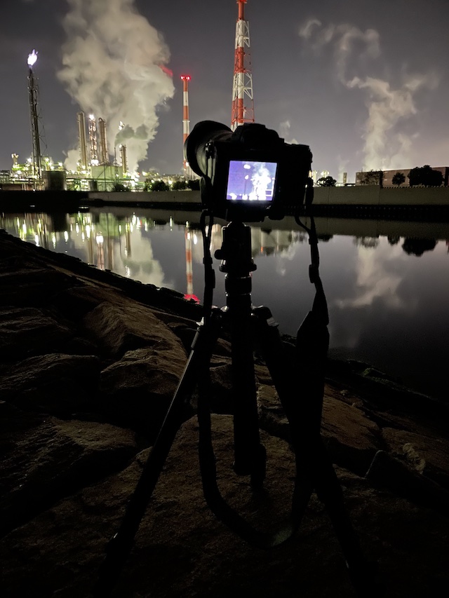 工場夜景を一眼レフカメラで長秒露光撮影している光景