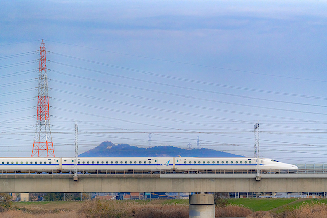 赤い鉄塔とトンネルのような鉄塔を入れて新幹線を先頭から２両半ぐらい入れて撮ってみました。